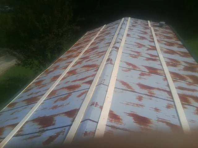 Rusted metal roof panels with new wood purlins before replacement — Storm Damage Roof Repair in Houghton by Roofing Brothers