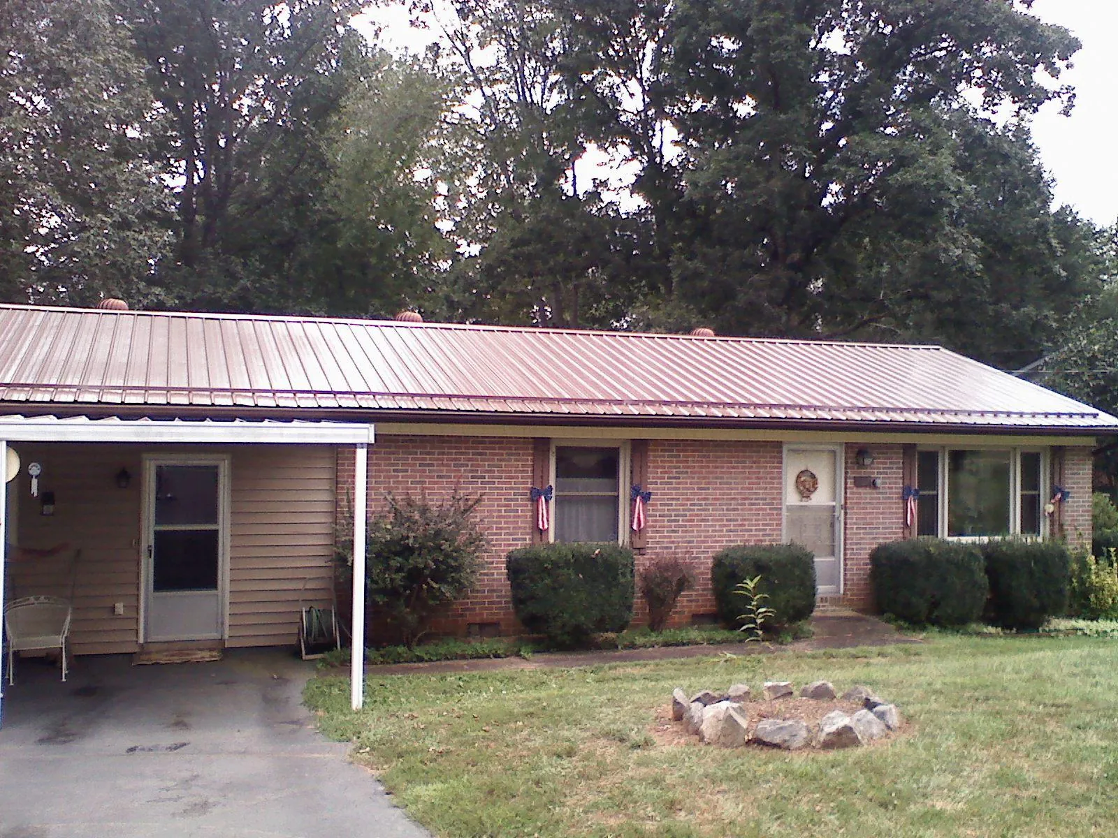 Bronze metal roof and carport on a brick ranch home — Roof Repair work by our crew in Houghton